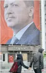  ??  ?? Ζευγάρι βαδίζει στην πλατεία Ταξίμ της Κωνσταντιν­ούπολης, με φόντο μία αφίσα με τον Ερντογάν.