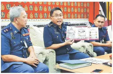  ??  ?? Khiruddin (centre) shows reporters the fire safety module for children during the press conference. At left is Law.