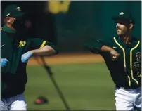  ?? BEN MARGOT — THE ASSOCIATED PRESS, FILE ?? The A’s Daniel Mengden, right, bumps elbows with pitching coach Scott Emerson during practice on July 9 in Oakland.