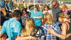  ?? AP PHOTO/JOHN LOCHER ?? People pray at a makeshift memorial for victims of the Oct. 1, 2017, mass shooting in Las Vegas on Sunday.