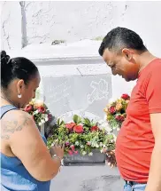  ??  ?? Luz Divina y su esposo Harold rezan frente a la lápida de su hija Gabriela, fallecida hace un año.
