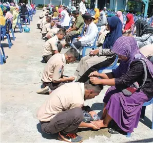  ?? SHOLIKHUL HUDA/JAWA POS RADAR JEMBER ?? SUNGKEM JELANG UN: Para siswa kelas XII SMKN 3 Bondowoso bersimpuh di depan orang tua mereka.