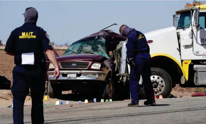  ?? Photograph: Bing Guan/Reuters ?? Law enforcemen­t at the scene of the deadly crash in Holtville, California.
