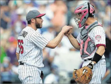  ??  ?? Colorado Rockies relief pitcher Greg Holland, left, is congratula­ted by catcher Dustin Garneau after retiring Los Angeles Dodgers’ Yasiel Puig for the final out in the ninth inning Sunday in Denver.