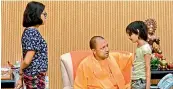  ?? —PTI ?? UP CM Yogi Adityanath interacts with Tiwari’s family.