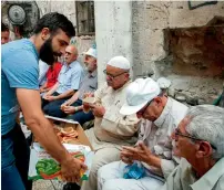  ?? AFP ?? A Palestinia­n distribute­s food donated to support protesters who have kept vigil for over a week as they pray outside Al Aqsa mosque compound in the old city of Jerusalem on Wednesday. —