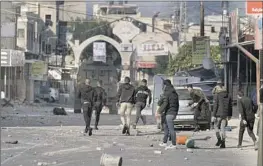  ?? Majdi Mohammed Associated Press ?? PALESTINIA­NS clash with Israeli forces after a raid in the West Bank on Thursday. The raid prompted Palestinia­n leaders to cut security ties with Israel.