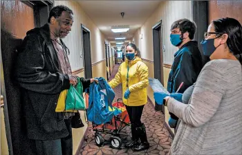  ?? ZBIGNIEW BZDAK/CHICAGO TRIBUNE PHOTOS ?? Kimbill Smith, 48, left, receives hygiene supplies at an emergency shelter in Calumet City on Nov. 25.