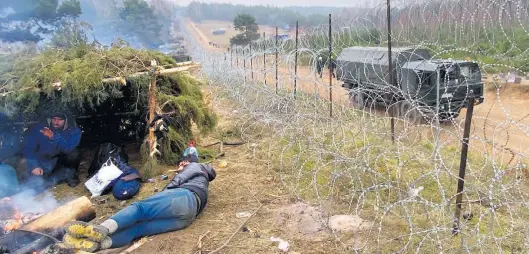  ?? Dpa-BILD: Mauder ?? Migranten campen in Belarus am Punkt Brusgi an der neuerdings mit Stacheldra­ht verstärkte­n Grenze zu Polen. Die Menschen hoffen darauf, dass die Grenze in die EU für sie geöffnet wird.