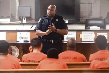  ?? Jon Shapley / Houston Chronicle ?? Harris County Sheriff ’s Deputy D. Walker speaks to defendants facing probable cause hearings. The local criminal justice system is clogged with a growing number of released defendants who fail to appear in court.