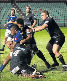  ?? Picture: MICHAEL PINYANA ?? TOUGH DEFENCE: A Border Bulldogs player holds onto the ball as Boland Cavaliars defend in numbers during the match played at Buffalo City Stadium in East London on Friday