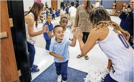  ?? [PHOTO BY CHRIS LANDSBERGE­R, THE OKLAHOMAN] ?? Michael Araiza gives a high-five to the Thunder Girls as he returns to class after a celebratio­n to honor Johnson Elementary students for being the top school in the ReadOKC summer reading program.