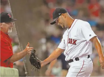  ?? STAFF PHOTO BY MATT WEST ?? BRIGHT SPOT: Red Sox starter Eduardo Rodriguez gets a hand from pitching coach Carl Willis after escaping a fifth-inning jam last night at Fenway.