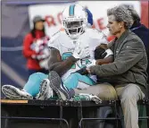  ?? STEVEN SENNE / ASSOCIATED PRESS ?? Dolphins running back Damien Williams grimaces as he is carted from the field with a shoulder injury in the second half of Sunday’s 35-17 loss to the Patriots.