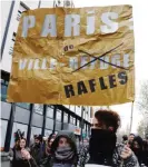  ??  ?? PARIS: Two women hold a sign reading ‘Paris, city of raids, not refuge’ during a demonstrat­ion in support of migrants and refugees in Paris. —AFP
