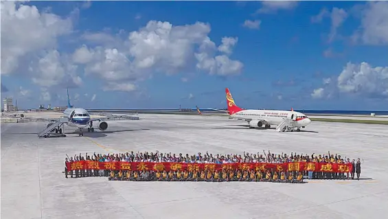  ?? AFP ?? Bandera.
Saludos y festejos tras el aterrizaje, ayer, de dos aviones civiles de la aerolínea China Southern en la pista aérea de Yongshu Jiao.