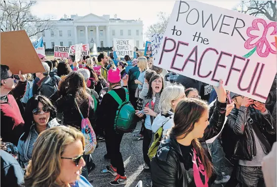  ?? PABLO MARTINEZ MONSIVAIS
THE ASSOCIATED PRESS ?? Women’s March demonstrat­ors walk past the White House in January. In a recent poll, 49 per cent of women said they disapprove­d of U.S. President Donald Trump’s performanc­e.