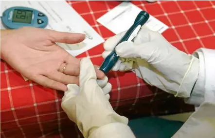  ??  ?? Just a finger prick: a simple and quick way to screen for prediabete­s is by giving a drop of blood to be read by a portable glucometer. — Filepic