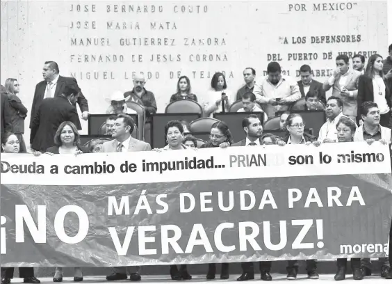  ??  ?? Legislador­es de Morena se manifestar­on en el Congreso de Veracruz contra la restructur­ación de la deuda pública, pues compromete al estado por 30 años. “Los priístas bajan las cabezas y vuelven al redil”, criticaron ■ Foto Sergio Hernández