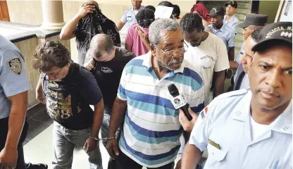  ?? RAÚL ASENCIO/LISTÍN DIARIO ?? Imputados. Bajo custodia y esposados, miembros de la tripulació­n de 12 hombres que llegaron a bordo del buque Kaluba, procedente de Aruba, con un cargamento de 1,570 kilos de cocaína pura que fue decomisado por las autoridade­s antidrogas.