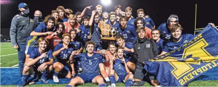  ?? SCOTT ASH / NOW NEWS ?? Marquette celebrates with a 2002 WIAA state soccer championsh­ip trophy after the Hilltopper­s’ victory Saturday. There was no trophy presentati­on due to the pandemic. The 2020 trophy will come in the mail.