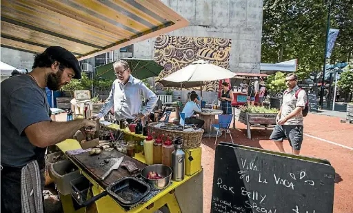  ?? BRADEN FASTIER/ THE LEADER ?? Matias Cacciavill­abi of Viva La Vaca prepares some lunches in Pocket Park, Bridge St.