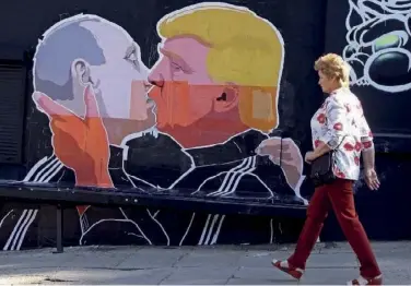  ??  ?? Illustrati­on du traditionn­el baiser russe entre Poutine et Trump sur un mur à Vilnius, en Lituanie.