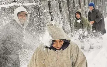  ?? AFP ?? Kashmiri youngsters engage in a snowball fight in Srinagar yesterday. Heavy snowfall lashed the Kashmir Valley yesterday and the Srinagar-jammu highway was closed for traffic to prevent accidents. Jammu and Kashmir summer capital Srinagar received six...