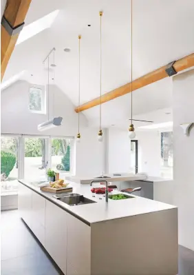  ??  ?? KITCHEN
The design (above) is focused on a long island with a bar at one end, helping to form a convivial L-shape, where the children eat breakfast and guests can gather.
Small ball pendant lights
with gold flex, £600 each, Michael Anastassia­des,...