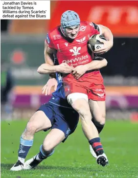  ??  ?? Jonathan Davies is tackled by Tomos Williams during Scarlets’ defeat against the Blues