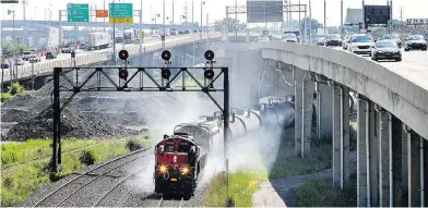  ?? JOHN MAHONEY / POSTMEDIA NEWS FILES ?? A freight train hauling oil tanker cars belches exhaust below the Ville Saint-Pierre Interchang­e in Montreal.