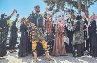  ?? HOSHANG HASHIMI AFP VIA GETTY IMAGES ?? A Taliban fighter stands guard as Afghan women protest against Pakistan in front of its embassy in Kabul on Tuesday.