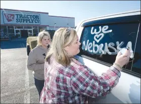  ?? NWA Democrat-Gazette/ANDY SHUPE ?? Tonya Bryant (right) of Prairie Grove and her daughter, Shai Bryant, write messages Thursday about Nebraska on their pickup with shoe polish while seeking donations of livestock supplies and feed at Tractor Supply in Farmington before heading out to Elkhorn, Neb., to assist in flooding recovery.