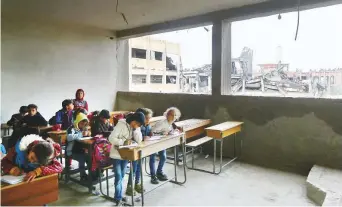  ?? Reuters ?? Children sit in a classroom at a school in Raqqa. With cold weather sweeping the region, children are finding it difficult to keep warm as schools have no windows or doors.