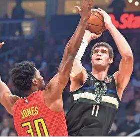  ??  ?? Milwaukee’s Brook Lopez launches a shot as Atlanta’s Damian Jones defends during the first half.