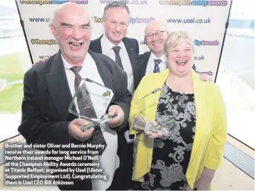  ??  ?? Brother and sister Oliver and Bernie Murphy receive their awards for long service from Northern Ireland manager Michael O’Neill at the Champion Ability Awards ceremony at Titanic Belfast, organised by Usel (Ulster Supported Employment Ltd)....