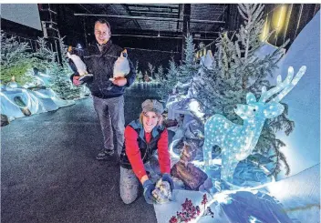  ?? FOTOS: MARKUS VAN OFFERN, DPA ?? Marcus Woll und Dorianne Broens dekorieren eine Schneeland­schaft am Rande der Auto-Schneise. Bis zu 13 Fahrzeuge sollen zeitgleich durch den „Drive-In-Weihnachts­markt“im Wunderland fahren können.