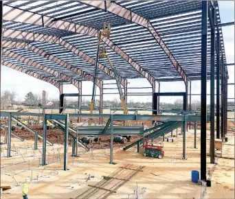  ?? TIMES photograph by Annette Beard ?? Beams to support the roof over the gymnasium of the new Pea Ridge High School were being installed Monday, Feb. 3, as constructi­on crews worked in every area of the new high school expected to be completed and ready to move in by mid-August 2020. School superinten­dent Rick Neal said the gym is designed to seat 1,850 people and the adjacent auditorium 750. The new building will house grades 10 through 12.