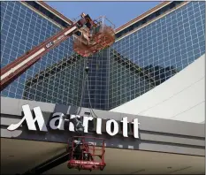  ?? AP PHOTO/DANNY JOHNSTON ?? In this April 30, 2013, file photo, a man works on a new Marriott sign in front of the former Peabody Hotel in Little Rock, Ark.
