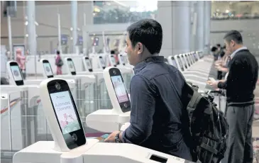  ??  ?? ABOVE A passenger passes through an automated immigratio­n control gate at Changi Terminal 4 in Singapore.