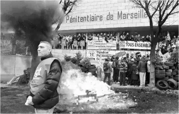  ??  ?? Prison guards block access to the Marseille prison during a demonstrat­ion as part of a nationwide movement to call for better safety and wages. — AFP photo