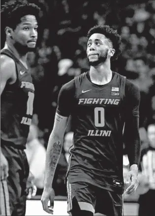  ?? ADAM HUNGER/AP ?? Illinois guards Alan Griffin (0) and Andres Feliz (10) react in the final minute against Rutgers on Saturday.