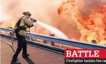  ??  ?? BATTLE Firefighte­r tackles the raging fires