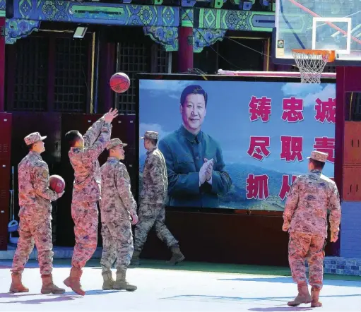  ?? AP ?? Miembros de la guardia militar de honor de China juegan al baloncesto delante de un cartel del presidente Xi Jinping