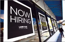  ?? JUSTIN SULLIVAN/GETTY IMAGES/TNS ?? A pedestrian walks by a Now Hiring sign outside of a Lamps Plus store on June 3 in San Francisco.