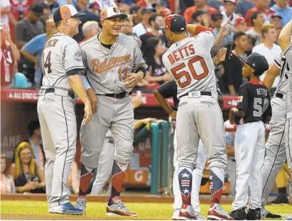  ?? KENNETH K. LAM/BALTIMORE SUN ?? Orioles shortstop Manny Machado, center, jokes with AL manager AJ Hinch, left, and Boston’s Mookie Betts during introducti­ons.