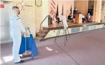  ?? CHRISTOPHE­R ARNOTT/HARTFORD COURANT ?? Petty Officer 2nd Class Devin Harshmann rings the memorial bell as Leslie Nieves, DVA director of residentia­l programs and colonel in the Connecticu­t Army National Guard, reads names of those who died on 9/11, in a ceremony Saturday in Rocky Hill.