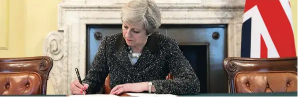 ?? Foto: Christophe­r Furlong, afp ?? Dem historisch­en Anlass angemessen, unterzeich­net die britische Premiermin­isterin Theresa May den Brexit Brief an die Europäisch­e Union mit einem Schreibger­ät der Luxusklass­e.