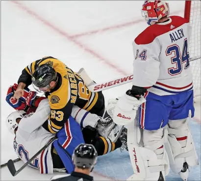  ?? MATT STONE — BOSTON HERALD ?? Brad Marchand (63) of the Boston Bruins starts pounding on Rem Pitlick of the Montreal Canadiens as goaltender Jake Allen looks on during the first period. The Bruins went on to capture a 4-2 win.