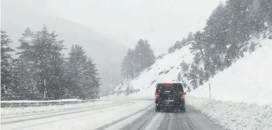  ?? X / @ADRIANHERR­FOS ?? Un vehículo circula ayer por una carretera cerca de Canfranc, en la provincia de Huesca, donde la nieve dificultó el tráfico.